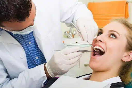 Dentist performing a professional teeth cleaning for a patient during a routine dental exam